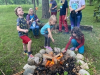 several children toasting marshmallows over a campfire